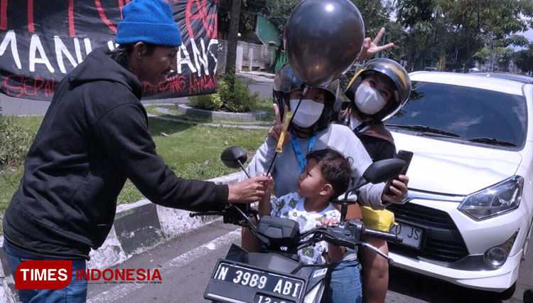 Suasana pembagian balon dan cokelat kepada para pengendara terjebak macet dan anak-anak yang melintas, Minggu (27/11/2022). (FOTO: Dok. Pribadi/TIMES Indonesia)