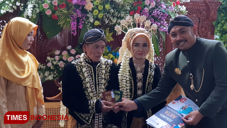 Bupati Ngawi menyerahkan buku nikah pada pasangan pengantin peserta resepsi Mas Bupati Ngawi Mantu. (Foto: Miftakul/TIMES Indonesia)