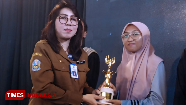 Kepala Bidang SMA Dinas Pendidikan Jawa Timur, Dra. Ety Prawesti, M.S.i menyerahkan trophy kepada pemenang Festival Millennial Entrepreneur Award (MEA)-2022 di Gedung Robotika ITS, Selasa (13/12/2022) siang. (FOTO: Lely Yuana/TIMES Indonesia)