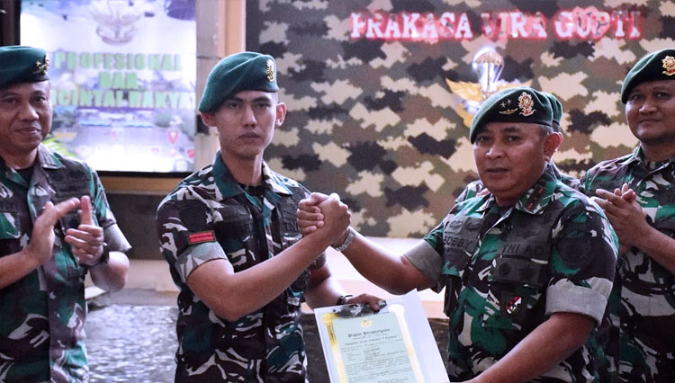 Pangdivif 1 Kostrad Mayjen TNI Bobby Rinal Makmun (kanan) menyerahkan piagam penghargaan kepada Pratu M. Hafifi yang mengamankan tiga orang geng motor bersenjata tajam. (FOTO: dok Kostrad)
