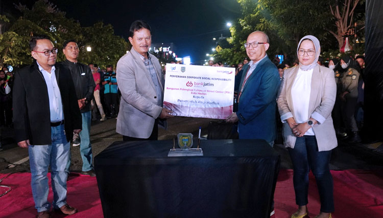 Direktur Mikro, Ritel dan Menengah Bank Jatim Arief Wicaksono secara simbolis menyerahkan bantuan CSR kepada Wali Kota Madiun H. Maidi pada Sabtu (31/12/2022) malam. (FOTO: Dok.Humas Bank Jatim)