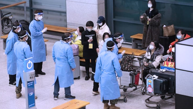 Petugas karantina memandu pelancong dari Tiongkok di aula kedatangan di Bandara Internasional Incheon, Rabu.(FOTO: The Korea Times)