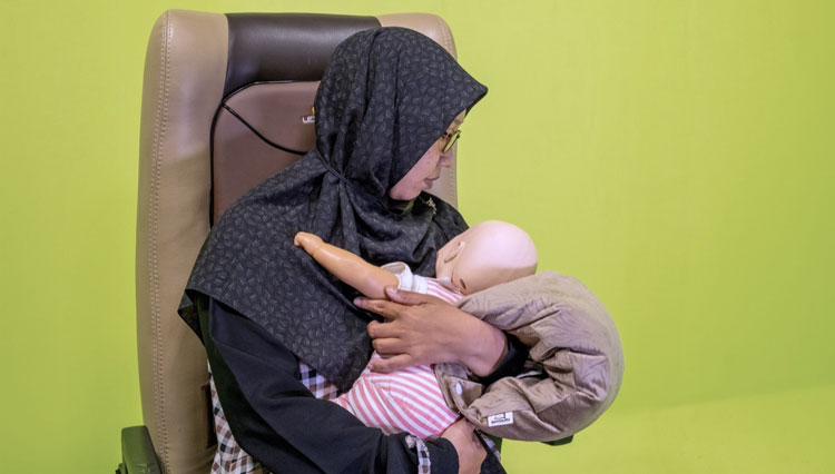 Tampak peraga seorang ibu saat menyusui anak menggunakan KORSIMU karya dosen Unisa Yogyakarta. (Foto: Unisa Yogyakarta)
