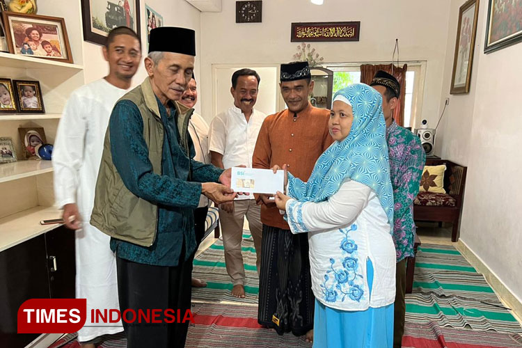 Abin Rais (jubah putih) mendampingi Ketua Muhammadiyah Kota Blitar menyerahkan uang saku pada guru ngaji yang berangkat umrah gratis, Sabtu (14/1/2023). (Foto: Sholeh/Times Indonesia)