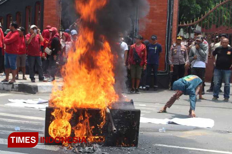 Aksi massa PKL diwarnai pembakaran rombong dan ban (yobby/Times Indonesia) Foto B : Aksi massa PKL diwarnai pembakaran rombong dan ban (FOTO: Yobby/TIMES Indonesia)