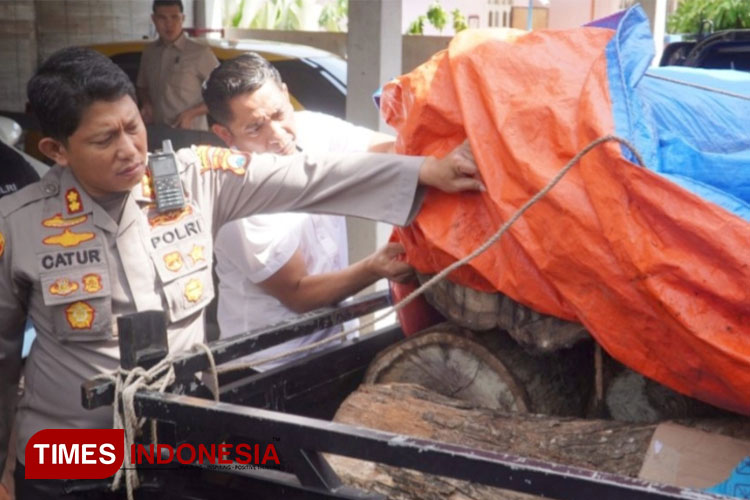 Kapolres AKBP Catur Cahyono Wibowo anggota Satreskrim Polres Ponorogo saat menunjukkan barang bukti kejahatan ilegal logging. (Foto: Marhaban/TIMES Indonesia)