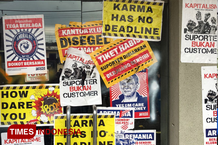 Sejumlah poster dan stiker yang ditempelkan di pintu Official Store Arema FC saat demo usut tuntas Tragedi Kanjuruhan. (Foto: Rizky Kurniawan Pratama/TIMES Indonesia)
