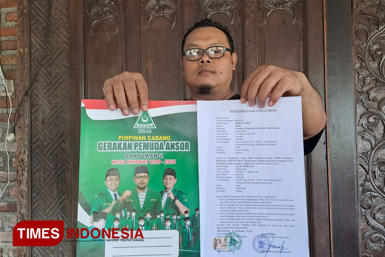 Joko Purnomo, SH, MH, kuasa hukum H Abdillah Rafsanjani, mantan Panglima Pasukan Berani Mati Pembela Gus Dur, memegang surat pernyataan dari Ketua GP Ansor Banyuwangi. (Foto: Syamsul Arifin/TIMES Indonesia)