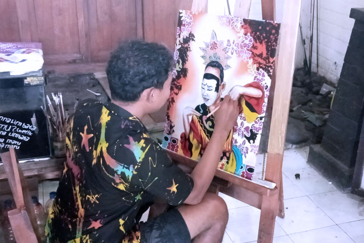 Ahyar Muzaki paint a figure on the batik. (Photo: Totok Hidayat/TIMES Indonesia) 