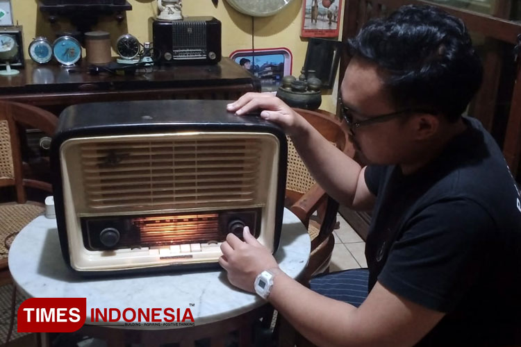 Ozy saat memperlihatkan radio lawas yang ia koleksi. (Foto: Rizky Kurniawan Pratama/TIMES Indonesia)