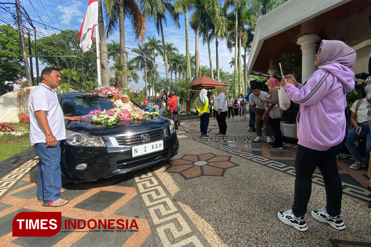 Masyarakat saat berfoto di mobil dinas Wali Kota Malang yang di khususkan bagi pengantin. (Foto: Rizky Kurniawan Pratama/TIMES Indonesia)