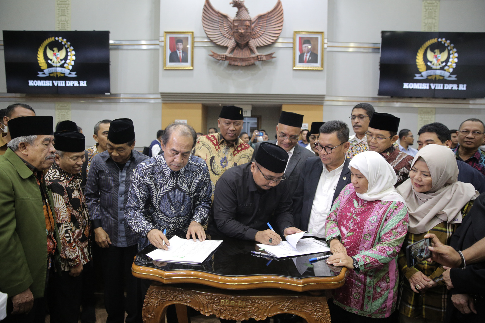 Ketua Komisi VIII Ashabul Kahfi bersama Menteri Agama Yaqut Cholil Qoumas menandatangani draft penetapan biaya haji 2023 dalam rapat dengan Komisi VIII di di kompleks Parlemen, Senayan, Jakarta, Rabu (15/2/2023). 