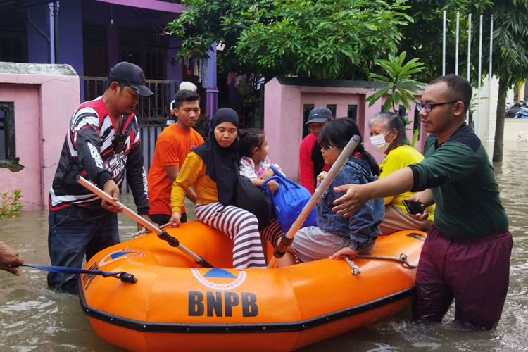 Tim BPBD Kota Solo mengevakuasi warga menggunakan perahu karet, Jumat (17/2/2203). (FOTO: BPBD Kota Solo)