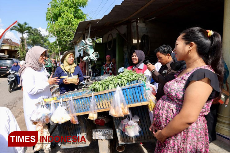 Salah satu pedagang mlijoan tengah menyalurkan bantuan makanan tambahan bagi balita stunting ataupun ibu hamil resiko tinggi (bumil risti). (Foto: Laila Yasmin/TIMES Indonesia)