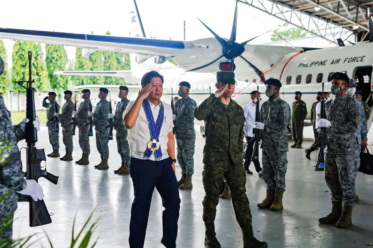 Presiden Filipina, Ferdinand Marcos Jr, kiri, saat memeriksa pasukannya di pangkalan udara di Kota Lapu-Lapu, provinsi Cebu, Filipina tengah. (FOTO: Al Jazeera/AP)