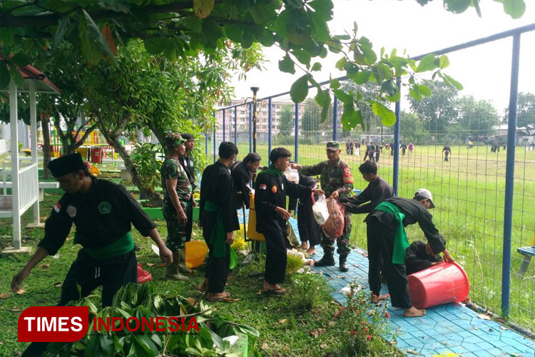 Anggota perguruan silat di Kota Kediri saat membersihkan taman bersama anggota TNI (yobby/Times Indonesia)