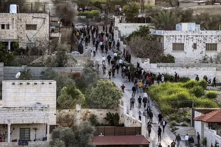 Orang-orang berkumpul di sepanjang jalan selama serangan tentara Israel di Jenin. (FOTO: Al Jazeera/AFP).