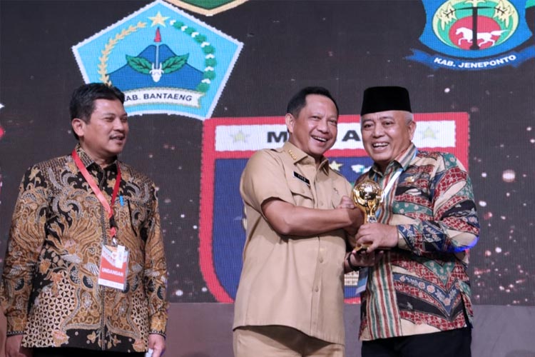 Bupati Malang Sanusi ketika menerima penghargaan UHC dari Mendagri. (FOTO: Prokopim Kabupaten Malang).