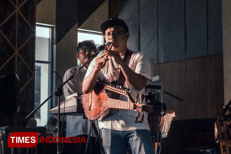 Ali Gardy Rukmana, memainkan Suling Jawa dan Dawai Sape' dalam penampilan di FKIP Universitas Jember.(Foto: Nafisah for TIMES Indonesia)