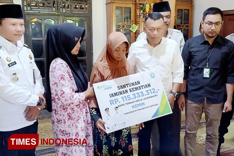 Bupati Sugiri Sancoko serahkan santunan jaminan kematian dari BPJS kepada ahli waris alm. Kemin pengurus RT Dusun Gunungan, Desa Ringinputih. (Foto: Marhaban/TIMES Indonesia)