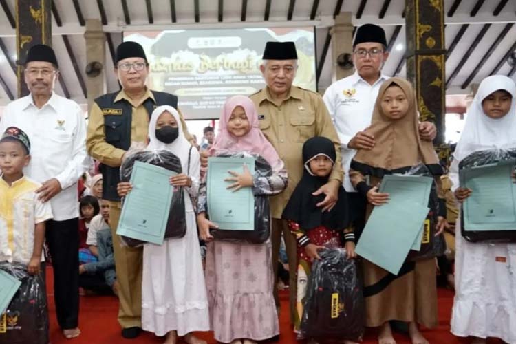 Bupati Malang Sanusi ketika menyerahkan santunan kepada anak yatim. (Foto: Prokopim Kabupaten Malang).