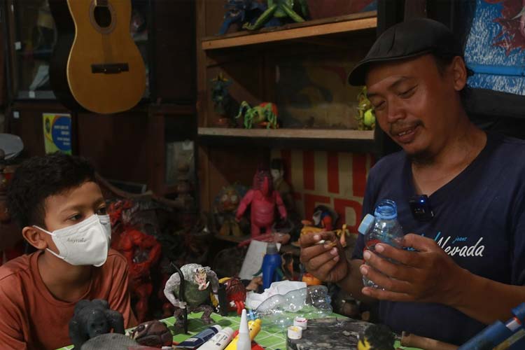 Seorang perajin dari Bank Sampah Pa-Q-One Art Production sedang mengolah sandal jepit bekas. (FOTO: Pemkot Yogyakarta)