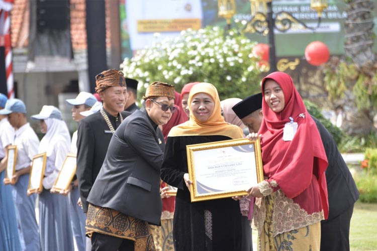 Momen saat Bu Risa mendapatkan piagam penghargaan dari Gubernur Jawa Timur, (Foto: Thursina IIBS Malang)