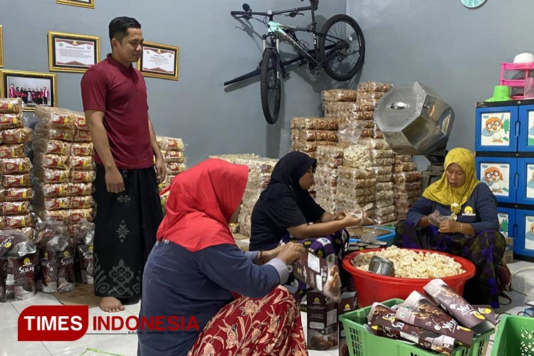 Mahfud, owner Sehati Snack sedang memproduksi kemasan camilan bersama karyawannya. (Foto: Abdul Jalil/TIMES Indonesia)