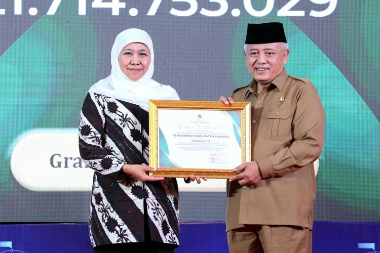 Bupati Malang Sanusi ketika menerima penghargaan e-purchasing dari Gubernur Jatim. (FOTO: Pemkab Malang)