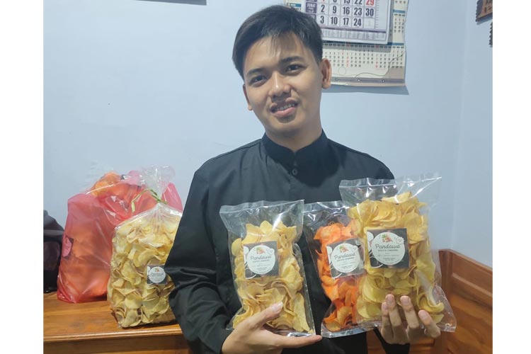 Guru honorer Febri Suliswanto (25) saat menawarkan produk olahan Keripik singkong pandawa di Jl. Nolojoyo RT.02 RW. 03 Desa Mojowarno, Kecamatan Mojowarno, Jombang. (FOTO: Bambang Cahyono/TIMES Indonesia)