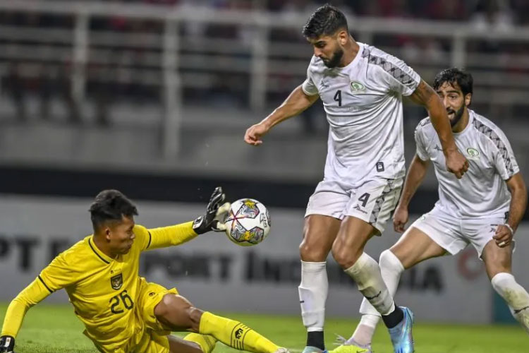 Penjaga gawang Timnas Indonesia Esyahrul Trisna Fadillah (kiri) menghalau tendangan pemain Timnas Palestina Yaser Hamed (kanan) pada pertandingan FIFA Matchday di Stadion Gelora Bung Tomo, Surabaya, (14/6/2023). (ANTARA FOTO/Muhammad Adimaja)