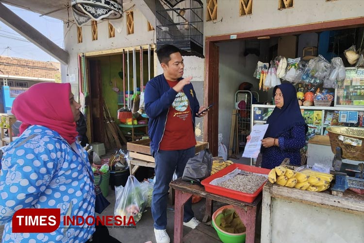 Seorang pedagang pasar yang telah menggunakan pembayaran QRIS. (Foto: Abdul Jalil/TIMES Indonesia)