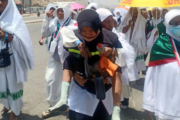 Nur Istibsaroh, salah seorang petugas haji Indonesia dari Media Center Haji (MCH) menggendong jemaah di Mina. (Foto: MCH 2023)