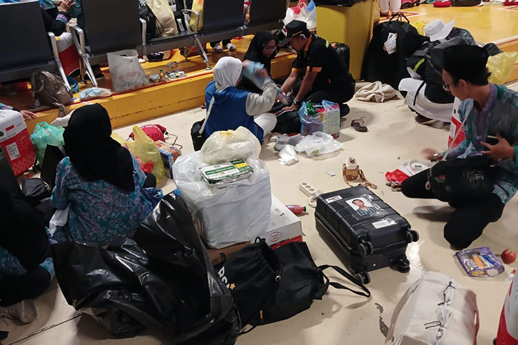 Jemaah dan petugas mengeluarkan barang bawaan yang overload untuk ditinggal di Makkah. (FOTO: MCH 2023) 