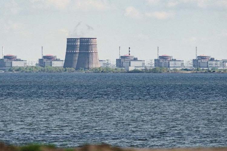 Pabrik Zaporizhzhia terlihat dari tepi sungai Dnipro pada 16 Juni 2023, setelah bendungan Nova Kakhovka jebol.(FOTO: AFP/ED JONES)