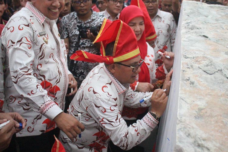 Wali Kota Gorontalo Marten Taha saat menyugukan tanda tangan di prasasti berukuran besar terletak di kawasan Pantai Losari Kota Makassar Rabu (12/07/2023). (Foto: Humas Pemkot Gorontalo) 