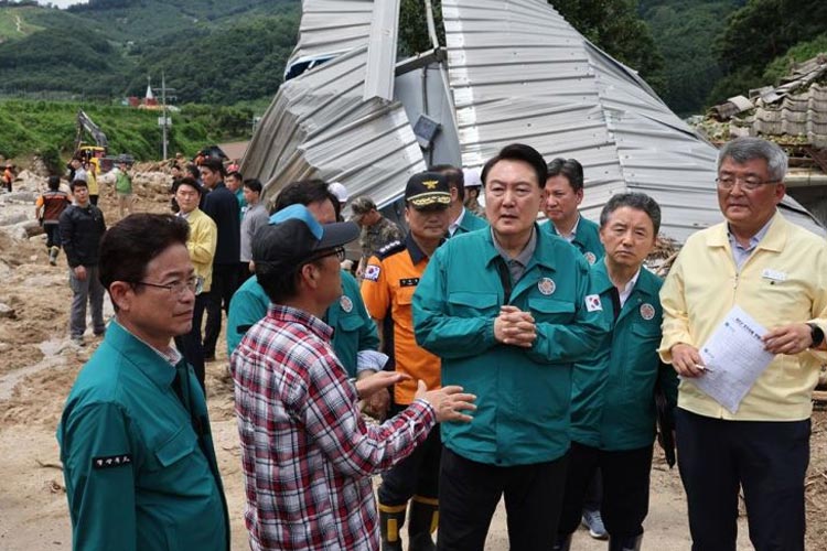Presiden Korea Selatan, Yoon Suk Yeol mendengarkan seorang warga saat berkunjung ke Yecheon, Provinsi Gyeongsang Utara, Senin, di mana tanah longsor yang fatal terjadi akibat hujan deras. (FOTO: Yonhap)