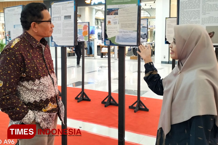 Koordinator Program Sembari BRIN, Dr. Evi Sopandi (Kiri) didampingi PJs Kepala SMAMIO Gresik Ulyatun Ni'mah meninjau projek riset siswa yang dipamerkan (FOTO: Akmal/TIMES Indonesia).
