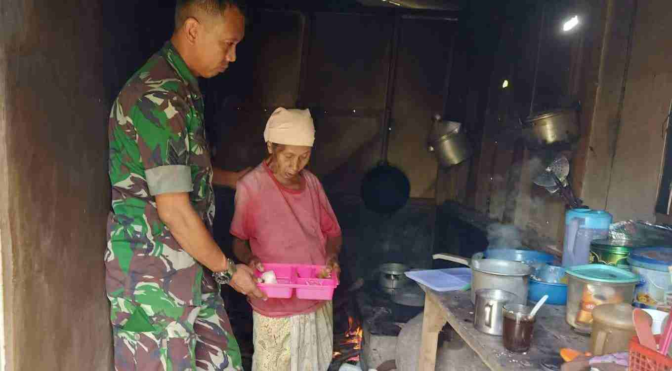Serka Fauzan Ali membantu Mbok Tuni di dapur rumahnya. (Foto: Babinsa 0833/TIMES INDONESIA)