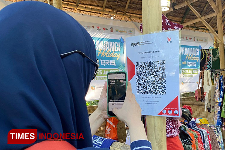 Pengunjung Banyuwangi Holiday With QRIS saat melakukan pembayaran melalui mobile banking dengan barcode QRIS. (FOTO: Fazar Dimas/TIMES Indonesia)