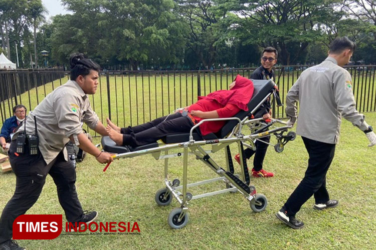 Salah satu warga saat ditandu petugas medis ketika menunggu kedatangan Presiden Jokowi di Pasar Rakyat Kota Malang, Senin (24/7/2023). (FOTO: Rizky Kurniawan Pratama/TIMES Indonesia)