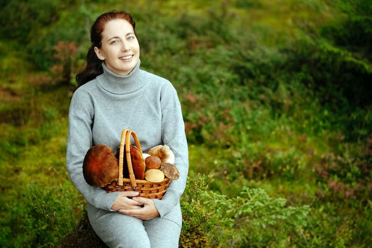 A girl holding a basket of mushrooms in her hands. (Photo: user34936046/Freepik)