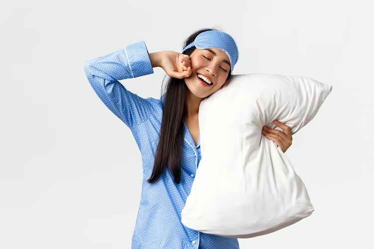 A lovely lady wearing blue pajamas waking up up from a good night's sleep. (Photo: Benzoix/Freepik)