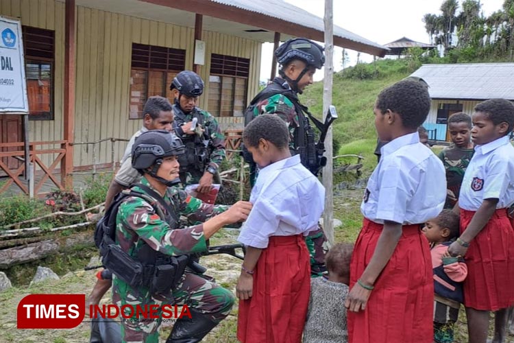 Prajurit Satgas Yonif PR 433/JS saat membagi dan mengenakan seragam baru secara gratis kepada anak-anak di Distrik Dal, Kabupaten Nduga, Papua. (FOTO: Satgas Yonif PR 433/JS for TIMES Indonesia)