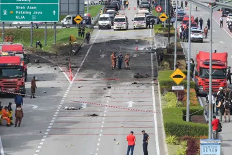 Para petugas tampak sedang melakukan penyelidikan di lokasi kecelakaan jatuhnya pesawat di jalan tol Selangor, Malaysia. Pesawat itu hancur berkeping-keping. (FOTO: CNN/AFP/Getty Image)