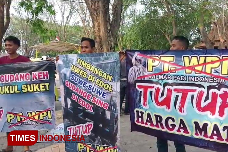 Para pemilik penggilingan padi saat membentangkan baliho bertuliskan tuntutan 'PT WPI Tutup Harga Mati' (FOTO: Muhammad Uqel Assathir/ TIMES Indonesia) 