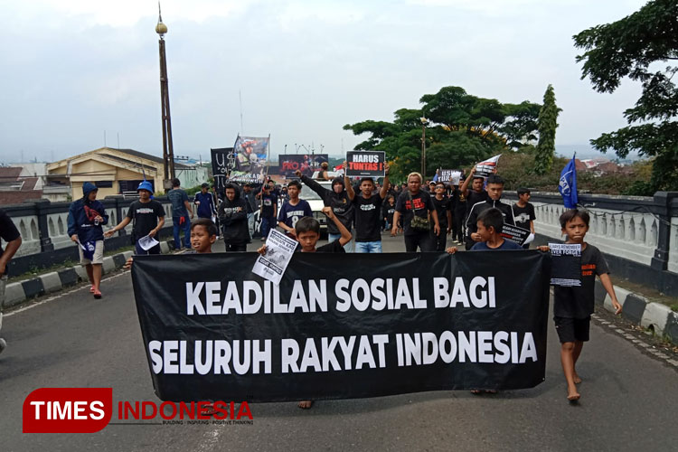 Aremania saat aksi kemanusiaan di Jalan Ahmad Yani menuntut aparat mengusut tuntas tragedi Kanjuruhan yang menelan korban 135 orang. (foto: dok TIN)