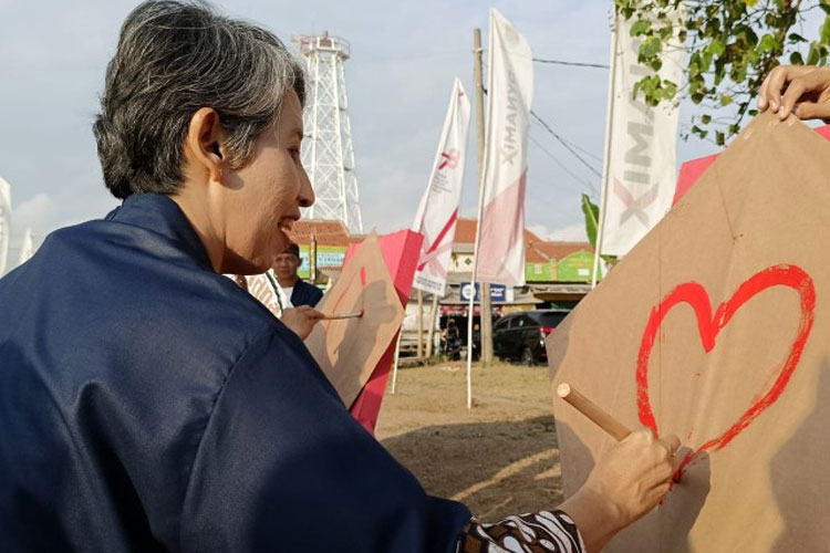 Pj Bupati Cilacap Yunita Dyah Suminar menorehkan coretan di atas layang-layang menandai dibukanya Festival Runtah. (FOTO: SBI Cilacap for TIMES Indonesia) 