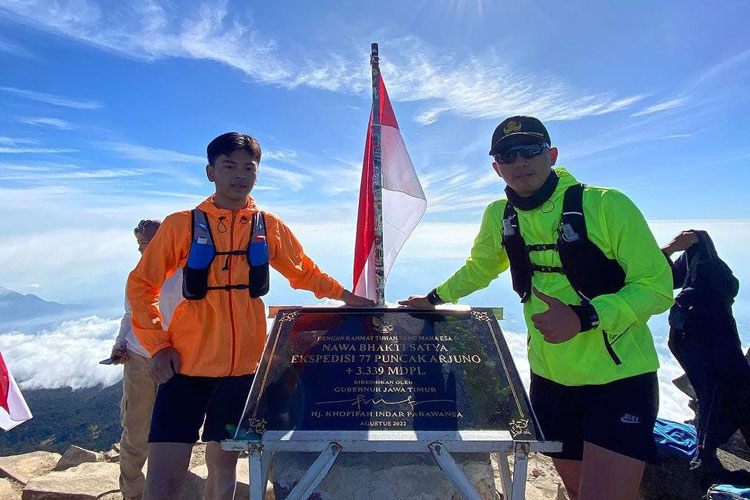 Wisatawan berfoto dengan Prasasti Nawa Bhakti Satya di Puncak Gunung Arjuno.(Dok.Humas Pemprov Jatim)