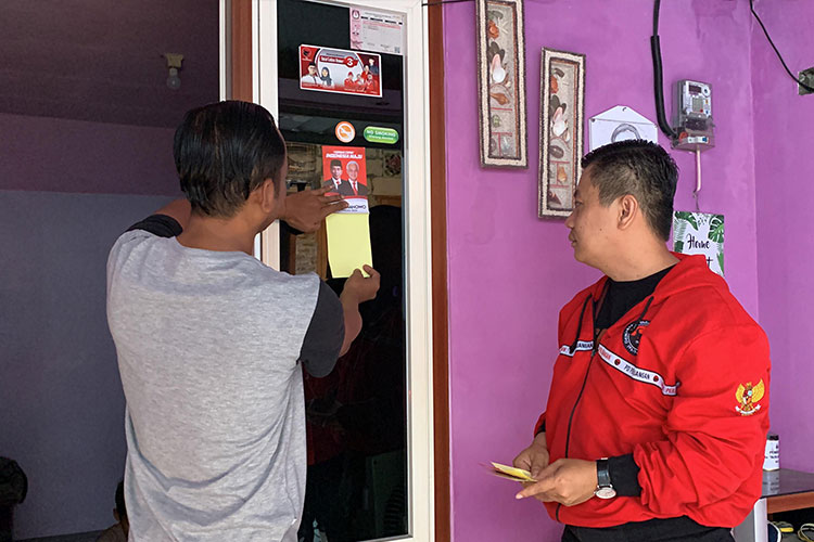 Warga menempelkan sticker bergambar Capres Ganjar Pranowo dan Jokowi di pintu dan cendelag rumah mereka (foto: dok dpc pdi perjuangan Sidoarjo)